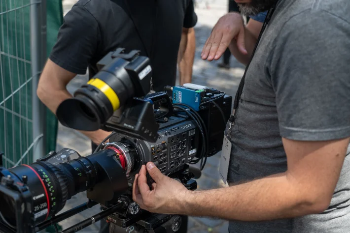 Operator handling a large-sensor cinema camera fitted with a Canon cine zoom on location